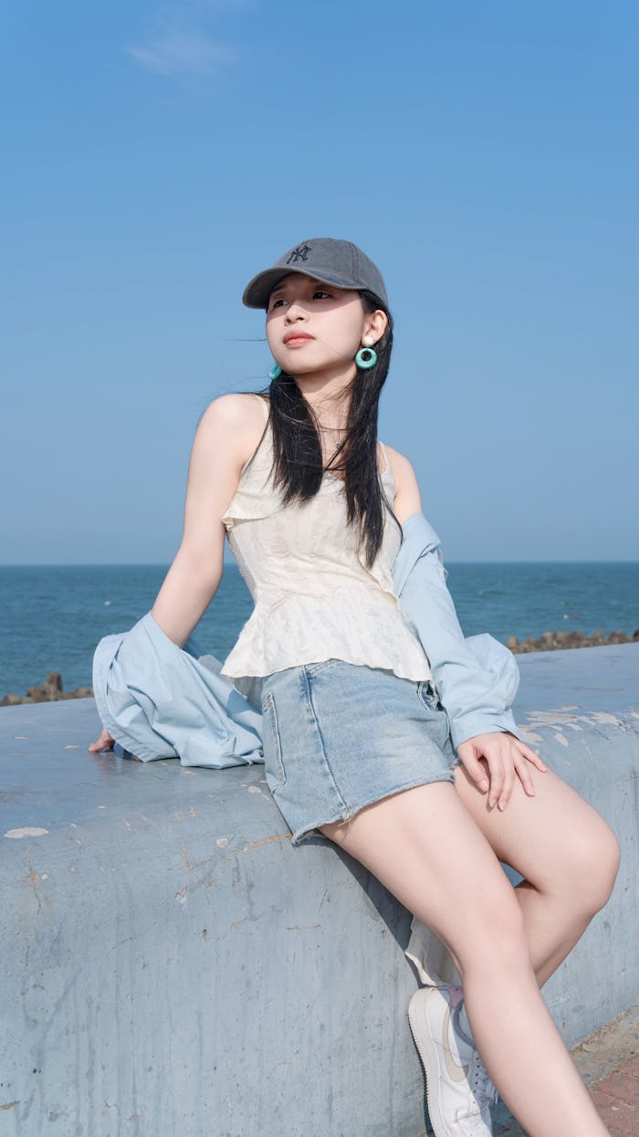 about-me-03 Stylish young woman in casual attire enjoying a sunny day by the sea.